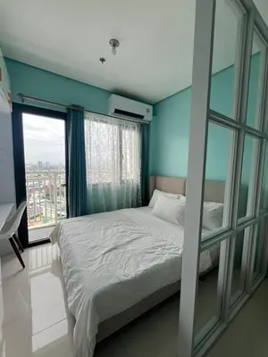 a bedroom with a bed and a large window at Lush Residence in Manila