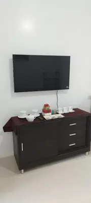 a black entertainment center with bowls and a cake on it at Derick's Place at Sea Residences in Manila