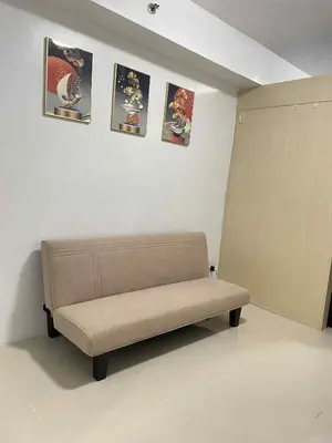 a couch in a room with pictures on the wall at Vonz Staycation Near Moa in Manila