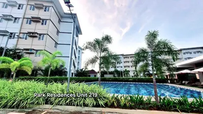 a hotel with a swimming pool in front of a building at PARK RESIDENCE Unit 219, SM City Santa Rosa, Laguna, by SMDC in Ibaba