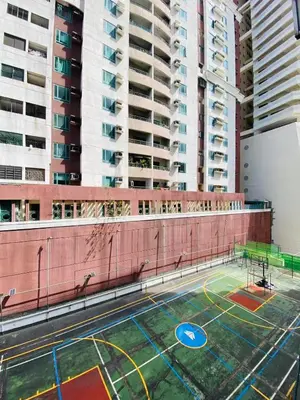 an empty basketball court on a building with tall buildings at Stan Condo in Manila