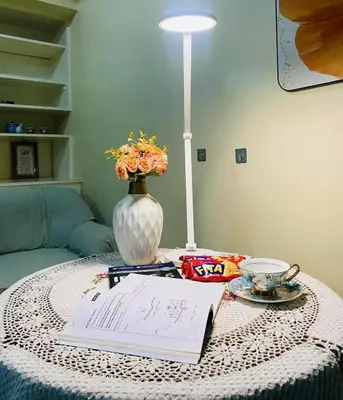 a table with a vase and a book on it at Stan Condo in Manila
