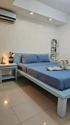 a bed with blue sheets in a room at Stan Condo in Manila