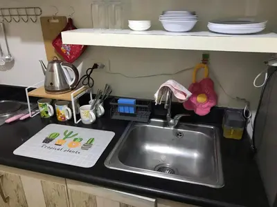 a kitchen counter with a sink in a kitchen at Cosy Studio with balcony 100mbps and Netflix in Manila