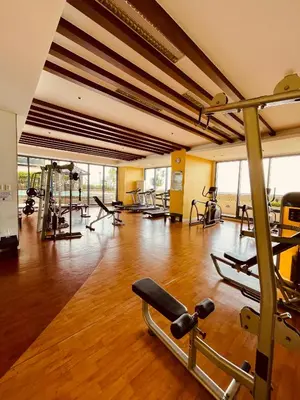 a gym with a bunch of exercise equipment in a room at Studio Unit at Grand Riviera Suites in front of US Embassy in Manila