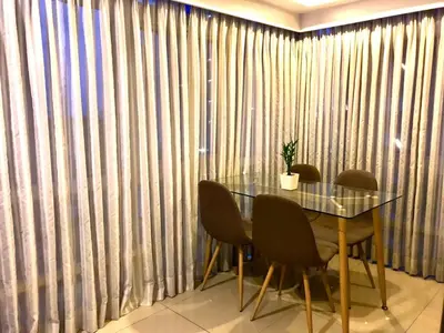 a table and chairs in a room with curtains at MaxStays - Max Home at Fort Victoria Tower A in Manila