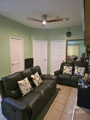a living room with a black leather couch at Home of Poli - 1BR with FREE Netflix & WiFi in Manila