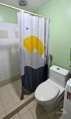 a bathroom with a toilet and a shower curtain at Home of Poli - 1BR with FREE Netflix & WiFi in Manila