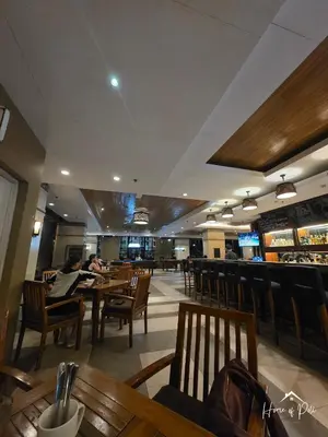 a restaurant with people sitting at tables and chairs at Home of Poli - 1BR with FREE Netflix & WiFi in Manila