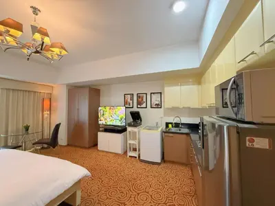 a hotel room with a kitchen and a bed at MaxStays - Max Home at The Venice Residences in Manila