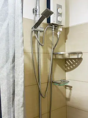 a shower with a shower head in a bathroom at STAYCATION CONDO SHORE RESIDENCES one bedroom w balcony pool view near SMX SM MOA IKEA NAIA DFA OCEAN PARK DFA in Manila