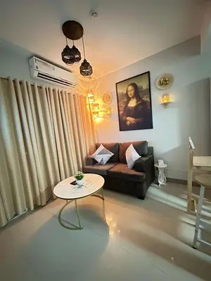 a living room with a couch and a table at Les Chambres Cosy - Sea Residences MOA PASAY in Manila