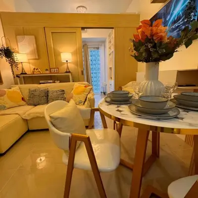 a living room with a table with a vase of flowers at Fourth's Jazz Cozy Pad in Manila