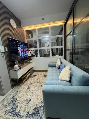 a living room with a blue couch and a tv at KD's Home - Fast WiFi, Netflix , Pool , Karaoke in Manila
