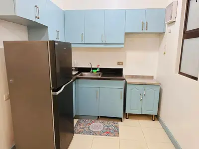 a kitchen with blue cabinets and a stainless steel refrigerator at Stan Condo in Manila