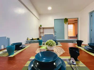 a dining room table with blue bowls and plates on it at Stan Condo in Manila