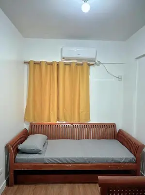 a couch in front of a window with a curtain at Stan Condo in Manila