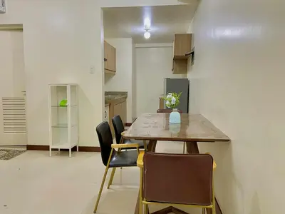 a dining room with a table and chairs at Vtan Condo in Manila