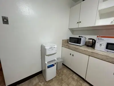 a small kitchen with a microwave and a refrigerator at 4Br House in Pasay near airport in Manila
