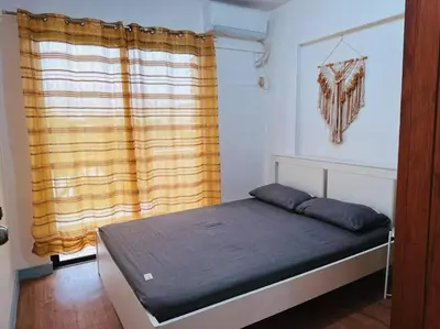 a bedroom with a bed and a window with curtains at Arista place staycation in Manila