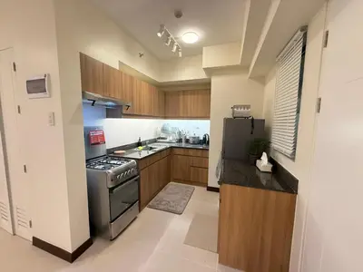 a kitchen with a stove and a refrigerator at The Camden Place 2BR Haven Cozy Condo Apartment Unit in Manila