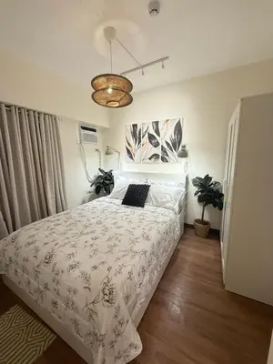 a bedroom with a bed with a white comforter at The Camden Place 2BR Haven Cozy Condo Apartment Unit in Manila