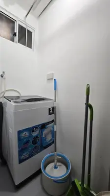 a washing machine and a mop in a room at Metrotowne PHINMA Las Pinas in Manila