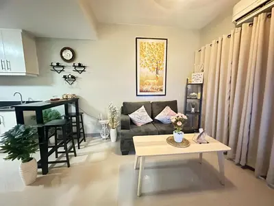 a living room with a couch and a table at Suite Elegante - Sea Residences Mall of Asia Pasay in Manila