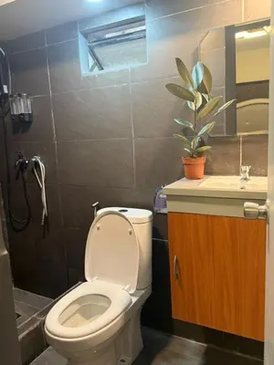a bathroom with a toilet and a sink at California Gardens square in Manila