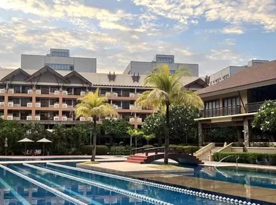 a hotel with a swimming pool in front of a building at Tropical Hawaiian 2BR Condo Unit in Metro Manila with Laundry Area - Sleeps 4 in Manila