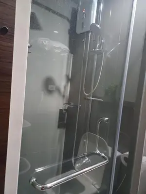 a glass shower door with a toilet in a bathroom at Florian's suite in Air Resideneces Makati in Manila