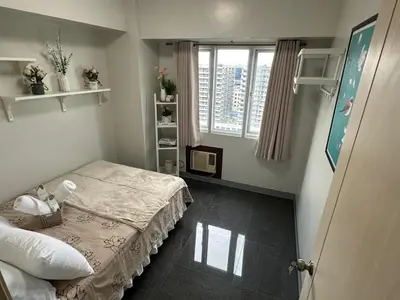 a small bedroom with a bed and a window at Suite Haven - Sea Residences MOA PASAY in Manila