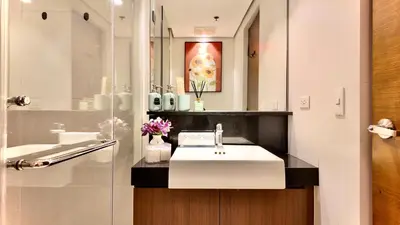 a bathroom with a sink and a mirror at Private Apartment walk to Greenbelt, Legazpi Village in Manila