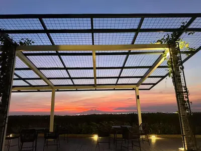 a patio with tables and chairs and a sunset at Modern 1BR with Magnificant Garden View, Near Airports, Okada, Solaire with Free Parking in Manila