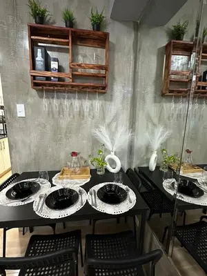 a black table with chairs and plates on it at Balai Bacasionan - Sea Residences MOA Pasay in Manila