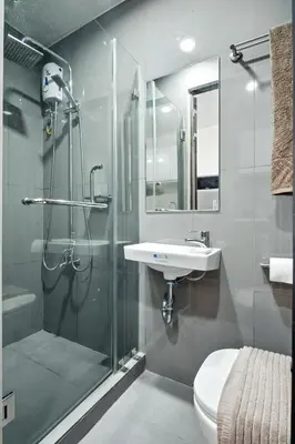 a bathroom with a shower and a toilet and a sink at Makati Penthouse Studio with City Views in Manila