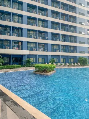 a swimming pool in front of a large building at Makati Penthouse Studio with City Views in Manila
