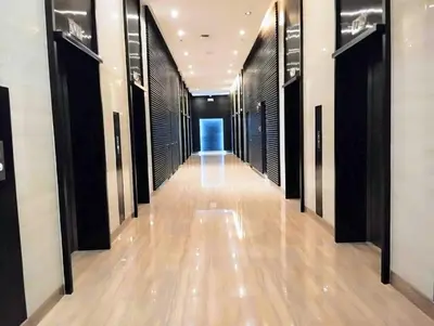 a long hallway with black doors and wooden floors at Makati Penthouse Studio with City Views in Manila