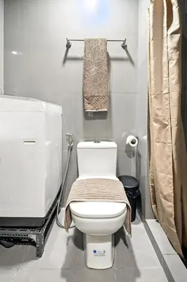 a bathroom with a white toilet and a sink at Makati 1BR with Skyline View at Air Residences in Manila