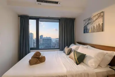 a bedroom with a bed with a teddy bear on it at Makati 1BR with Skyline View at Air Residences in Manila