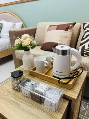 a coffee table with a coffee maker and cups on it at Metro Stay Grand View Tower in Manila