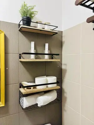 a bathroom with towels on shelves in a bathroom at Metro Stay Grand View Tower in Manila