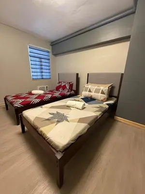 a bedroom with two beds and a window at 2 bedroom loft type with 2 baths Near Rockwell in Manila