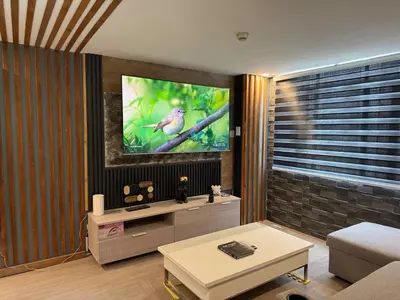 a living room with a tv on a wall at 2 bedroom loft type with 2 baths Near Rockwell in Manila