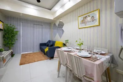a dining room with a table and a couch at 1Bed Room Staycation at Green Residences in Manila