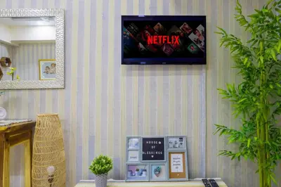 a living room with a tv on a wall at 1Bed Room Staycation at Green Residences in Manila