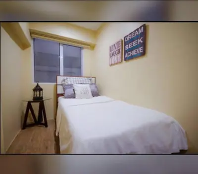 a bedroom with a bed and a sign on the wall at NEW AND AFFORDABLE 2BR LOFT at THE FORT BGC 200mbps WiFi in Manila