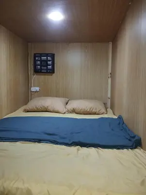 a bed in a room with a wooden wall at Capsule bed in Manila
