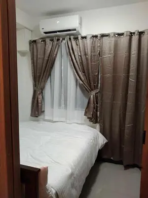 a bedroom with a bed and a window with curtains at 1 BR- with Balcony -Shore 2 Tw2 - Pasay MOA in Manila