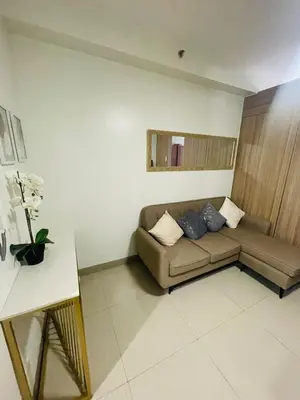 a living room with a couch and a table at Shore 2 Residences Moa Pasay in Manila